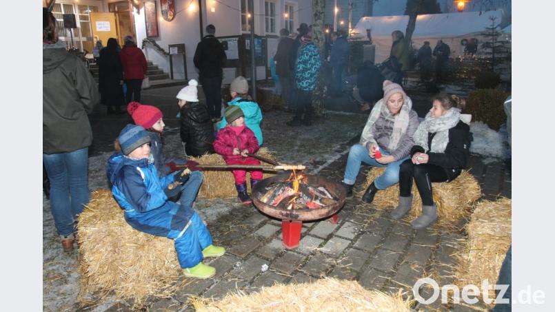 Am Lagerfeuer bereiten Kinder ein Stockbrot zu. Bild: pi
