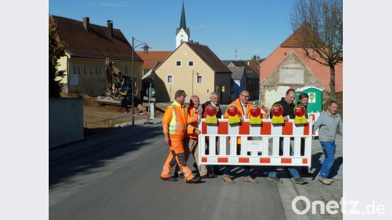 Bevor der Bauhof am Dienstagnachmittag die Absperrungen an der Ortsdurchfahrt wegräumte, legten schon mal die Ehrengäste fürs Pressefoto Hand an: Bauhofchef Anton Köppl (von links), Baudirektor Gottfried Weishäupl, Planer Hans Böckl (Ingenieurbüro Weiss), Bürgermeister Max Beer sowie von der bauausführenden Firma der Inhaber Helmut Seebauer, Bauleiter Matthias Vogl und Vorarbeiter Josef Schneeberger. Bild: Portner