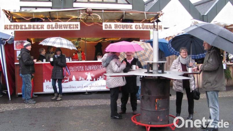 Für Wärme sorgen Stehtische mit Öfen in der Mitte. So lässt es sich auch bei Nieselregen auf dem Weihnachtsmarkt aushalten, sofern man noch einen Regenschirm dabei hat. Bild: sei