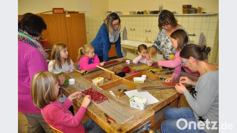 Als Eckpunkte für ihre Fadenbilder schlagen die Kinder und Mütter Nägel in alte Bretter. Die Metallstifte verbinden sie dann mit Wolle, wodurch ein Bild entsteht. Bild: ak