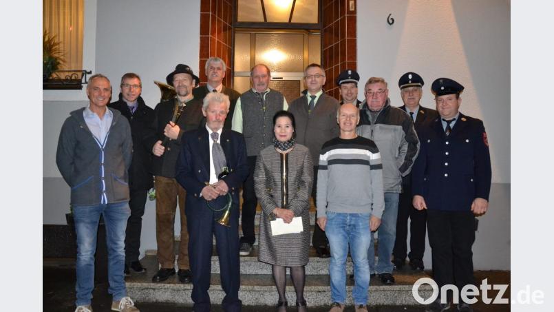 Josef Steinberger (vorne, Vierter von links) feiert seinen 80. Geburtstag. Dazu gratulieren Frau Oanh, Bürgermeister Hermann Ach, Vereinsabordnungen sowie die Jagdhornbläser unter der Leitung von Eduard Forster. Bild: gi