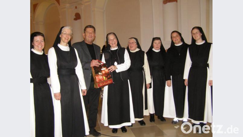 Bei der Vorpremiere in der Klosteraula nimmt Peter Giesecke von Äbtissin Laetitia Fech ein Tüte mit Spezialitäten aus der Abtei entgegen. Bild: pz