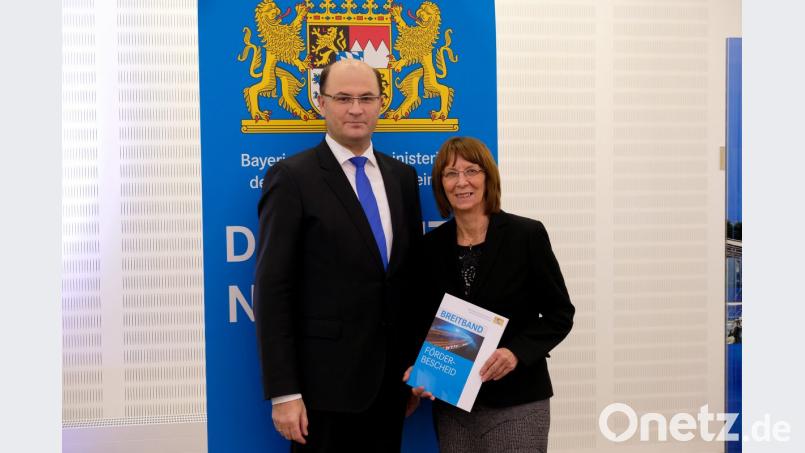 Minister Albert Füracker überreicht Bürgermeisterin Margit Kirzinger den Bescheid zur Förderung des Breitbandausbaus. Bild: fjo