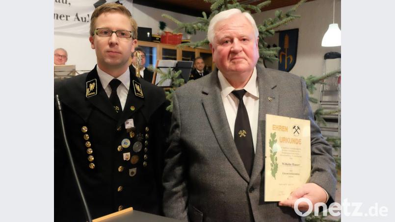 Der Vorsitzende des Bergknappenvereins Stulln/Schwarzenfeld, Jürgen Ferschl (links), überreicht Wilhelm Hauser (rechts) für hervorragende Verdienste die Urkunde zur Ernennung als Ehrenvorsitzender. Bild: ohr