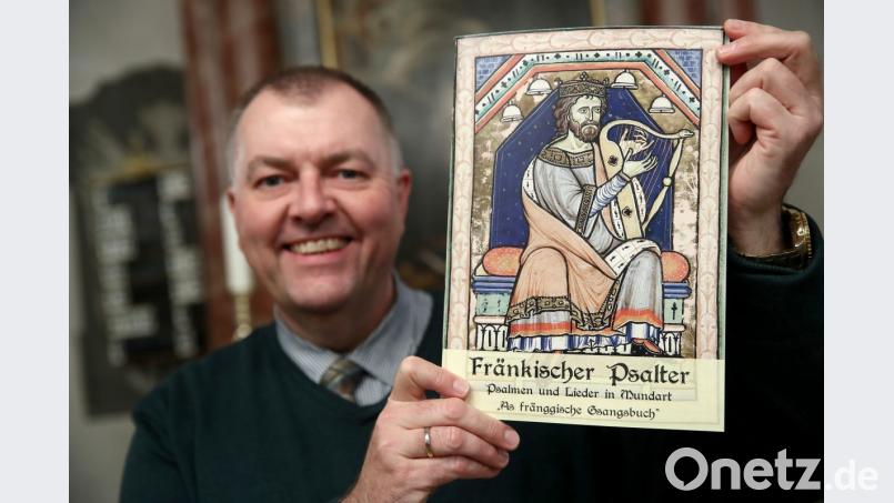 Pfarrer Claus Ebeling hält das Kirchliche Mundart-Gesangbuch "Fränkischer Psalter - Psalmen und Lieder in Mundart - As fränggische Gsangsbuch" in der Dreieinigkeitskirche in den Händen. Das spezielle Gesangbuch für Franken beinhaltet nicht nur das fränkische "Vaterunser", sondern insgesamt 23 biblische Psalmen und 44 Lieder auf 80 Seiten. Darunter auch Dialekt-Fassungen von bekannten Weihnachtsliedern. Bild: agentur_dpa