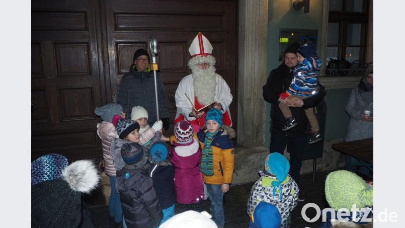 Die Kinder umzingeln den Weihnachtsmann und halten gemeinsam den Bischofsstab. Bild: gz