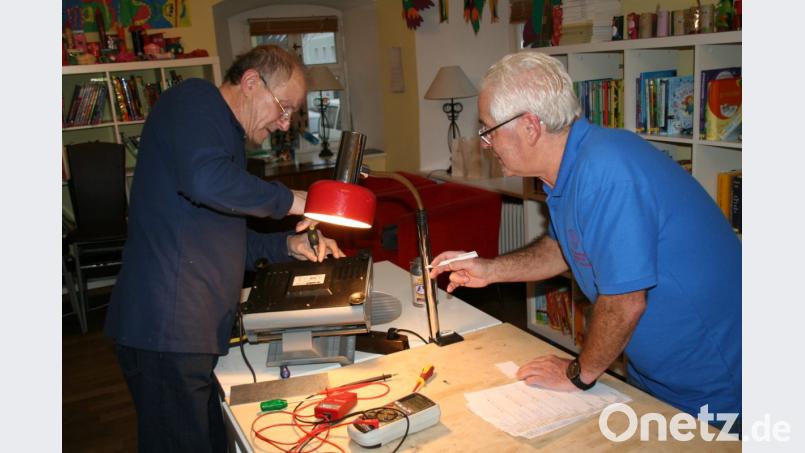 Ewald Weber stellt kurzerhand die Brotschneidemaschine auf den Rücken und sucht den Fehler. Kurz darauf läuft das Gerät wieder. Währenddessen notiert Josef Nachbar die ausgeführten Arbeiten für das Archiv. Bild: fpoz