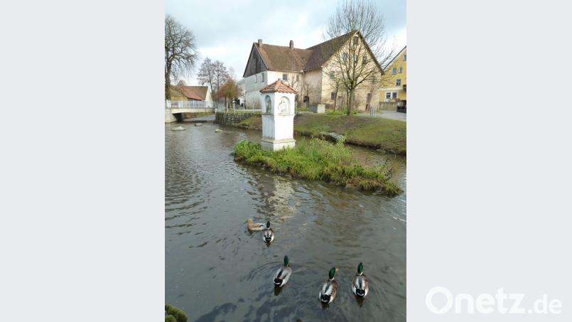Ruhig und idyllisch präsentiert sich die Ortsmitte von Teunz. Die Gedenksäule in der Murach erinnert an das Jahr 1760, als die halbe Ortschaft bei einem Hochwasser vernichtet wurde. Bild: Portner