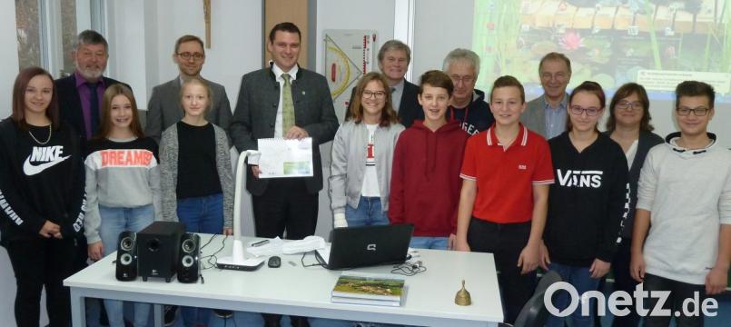 Achtklässler der Doktor-Eisenbarth-Mittelschule überreichten an Landrat Thomas Ebeling (Mitte) den Bildungsatlas 2018. Über die Projektarbeit freuten sich auch Schulamtsdirektor Georg Kick (hinten von links), Florian Schmid (Bildungsmonitoring), Rektor Werner Winderl, Klassenlehrer Alois Köppl, Konrektor Rudi Schneider und Fachlehrerin Marina Schießl. Bild: Portner