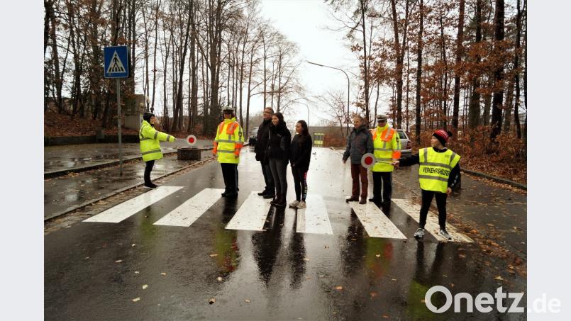 Zwei Schüler sichern den Überweg ab. Polizeihauptmeisterin Manuela Weidhas (Zweite von links) und Polizeihauptkommisar Tobias Wirth (Zweiter von rechts), schauen den Schülern und Lehrkräften zu, ob sie richtig lotsen. Bild: arw