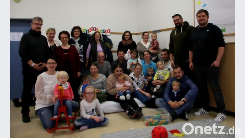 Marianne Fütterer (stehend, Dritte von links) unterstützt die kommunalen Familienbeauftragen Anita Thoma (stehend, Fünfte von links) und Nicki Fürst (stehend, Sechste von links), die mit der Marktgemeinde junge Eltern und Elke Schnabel (stehend, Vierte von links) zum Familiennachmittag eingeladen haben. Links im Bild Bürgermeister Wolfgang Braun. Bild: wro