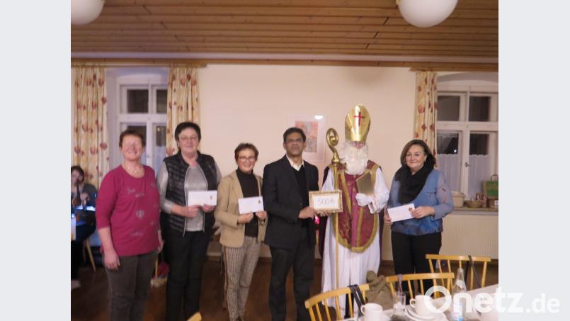 Der Nikolaus (Regina Frank) übergibt Spenden an Nicole Fürst (rechts), Gisela Pscherer, Edith Lippert, Pater Joseph (Zweite, Dritte und Vierter von links). Ganz links steht Sprecherin Rita Ponnath. Bild: jzk