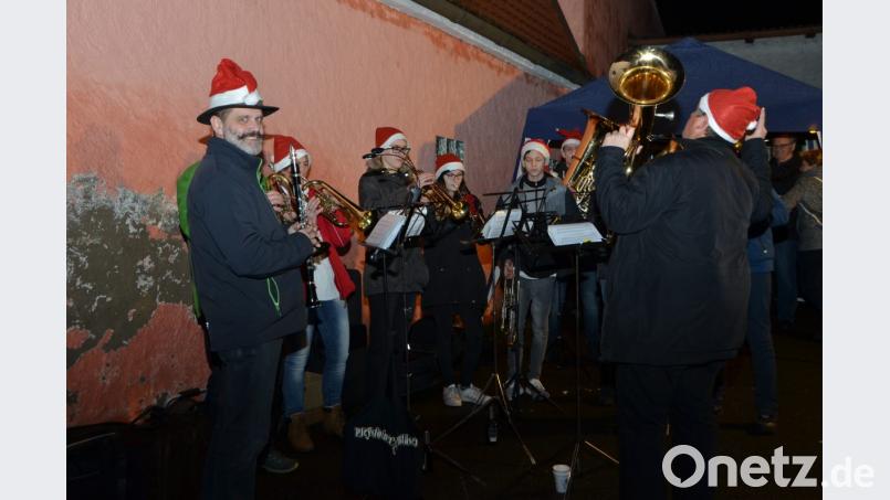 Rotbezipfelt kamen die &quot;Pleystoiner Bläser&quot; in die Wittschauer Straße und spielten weihnachtliche Weisen. Bild: dob