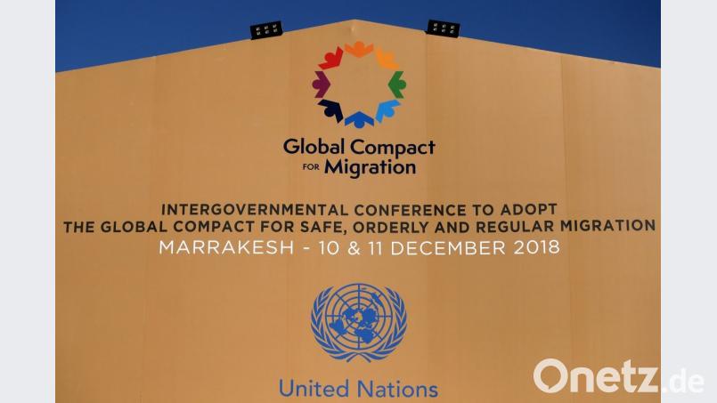 Die Logos der Vereinten Nationen und des Migrationspakts an einem Gebäude in Marrakesch. Bild: Eric Lalmand/BELGA/dpa