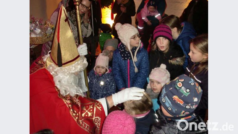 Die Kinder hatten schon sehnlichst auf ihn gewartet: Der Nikolaus beschenkte die Buben und Mädchen. Bild: aub