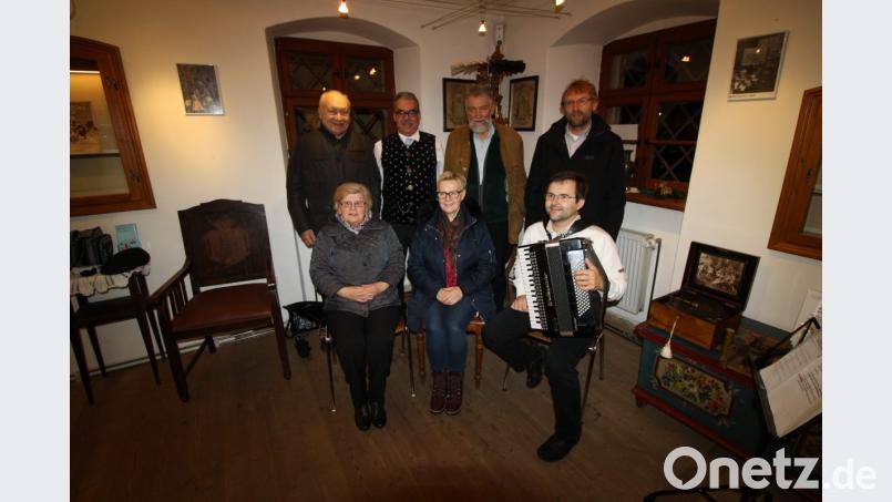 Monika Fink, Sieglinde Wick und Roland Küffner (sitzend, von links) begleiten die Ausstellungseröffnung mit weihnachtlichen Volksweisen. Darüber freuen sich Kreisheimatpfleger Robert Schön, Museumsleiter Anton Heindl, HAK-Vorsitzender Hans Rösch und zweiter Bürgermeister Hermann Schraml (stehend, von links). Bild: bjp
