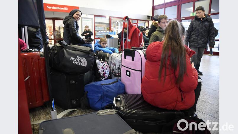 Eigentlich sollte die fünfte Klasse der Dreifaltigkeits-Mittelschule schon auf dem Weg ins Schullandheim sein. Notgedrungen machen es sich die Buben und Mädchen im Amberger Bahnhof bequem. Bild: Petra Hartl