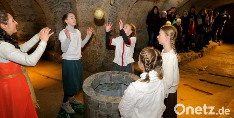 Die Kinder werfen sich die goldene Kugel solange zu, bis sie in den Brunnen fällt. Bild: Hirsch
