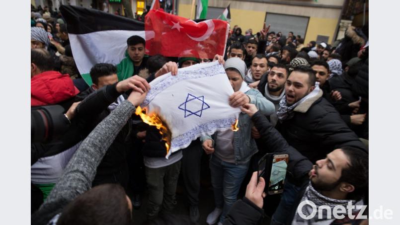 Teilnehmer einer Demonstration in Berlin verbrennen eine selbstgemalte Fahne mit einem Davidstern. Ihr Motiv Judenfeindschaft. Bild:  -/Jüdisches Forum für Demokratie und gegen Antisemitismus e.V./dpa