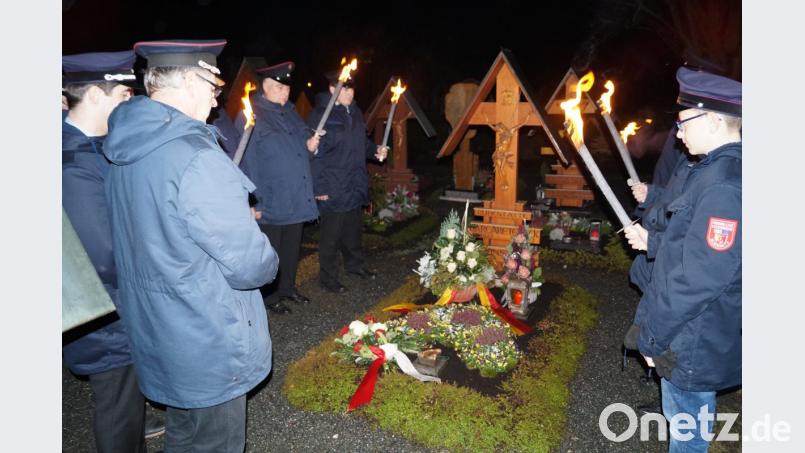 Im Fackelschein gedenken die Aktiven der Schirmitzer Wehr am Grab ihres vor 20 Jahren verstorbenen ehemaligen großen Förderers und Vorsitzenden Alfons Bock. Bild: du