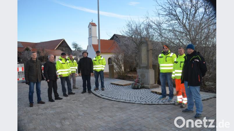 Mit der Baufirma, Planern und Verantwortlichen zeigt sich Bürgermeister Gerhard Scharl (zweiter von links) zufrieden über den neu gestalteten Kapellenplatz in Trebsau mit der Kapelle im Hintergrund. Bild: fz