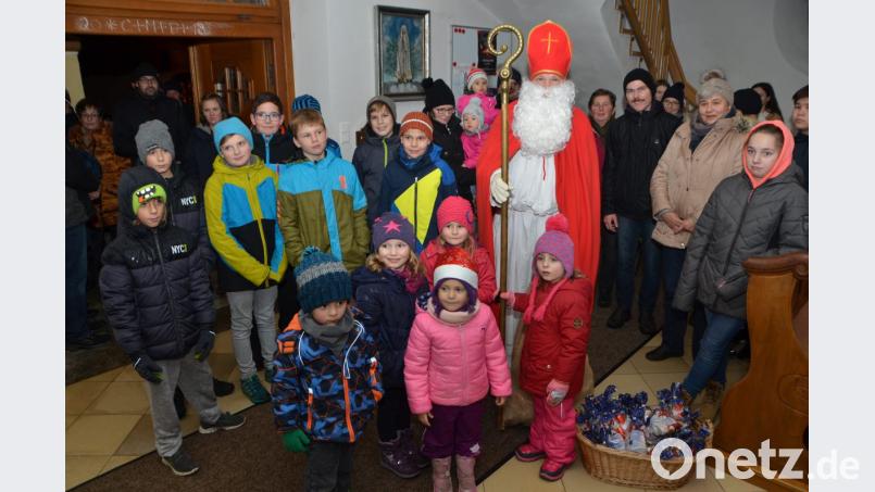 Große und kleine Kinder umringen den heiligen Mann, der viel Gutes über die Ortsteilbewohner zu berichten hat und deshalb die Rute lieber im Sack lässt. Vielmehr verteilt er süße Geschenke an den Nachwuchs. Bild: dob
