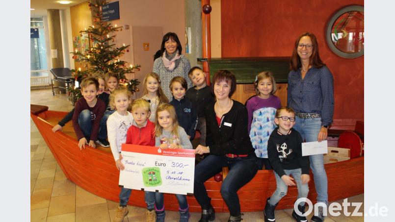 Iris Wiedmann (rechts) und Manuela Fuhrmann (hinten) kommen mit elf Vorschulkindern aus dem Kinderhaus St. Michael, um an Anja Schricker (Vierte von rechts) vom Bunten Kreis Nordoberpfalz 300 Euro zu überreichen. Bild: exb/Kliniken Nordoberpfalz AG