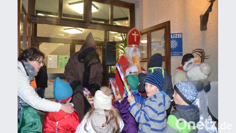 Die Kinder freuen sich über die kleinen Geschenke, die der Nikolaus am Rathaus verteilt. Bild: jub