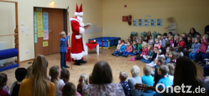 Knapp einhundert Kinder freuen sich über den hohen Besuch im katholischen Herz-Jesu-Kindergarten. Der junge Jonas darf den Stab des Bischofs halten, der sich über die eigens einstudierten Beiträge der Kinder besonders freut. Bild: mez