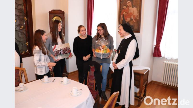 Die Schülersprecherinnen Judith Moser, Samantha Eckert, Laura Bitterer und Franziska Zintl (von links nach rechts) bringen Mt. M. Laetitia mit ihren Geschenken, einem selbst erstellten Foto-Adventskalender und Obstkorb, zum Strahlen. Bild: exb