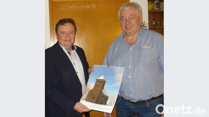 Gast- und Landwirt Josef Schiml übergibt den Kalender an Bürgermeister Gerhard Kellner. Bild: Rupert Seitz