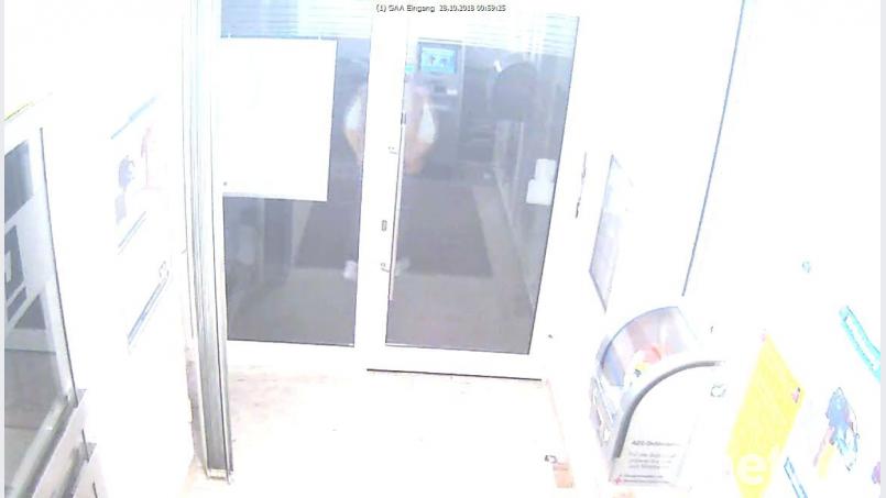 Ein wenig schwer zu erkennen: Diese Aufnahme der Überwachungskamera zeigt den späteren Täter gegen 0.49 Uhr vor der Bank. Bild: Polizei Amberg