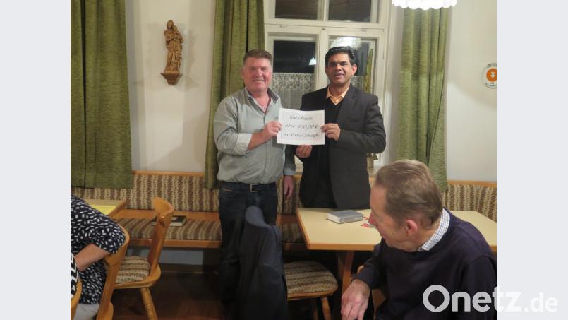 KAB Vorsitzender Peter Daschner überreicht Pater Joseph einen Gutschein über 600 Euro. Bild: jzk