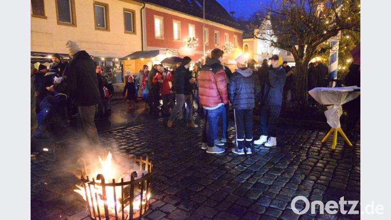 Rund um die wärmenden Feuer gruppieren sich die Gäste beim Adventsmarkt. Bild: bey
