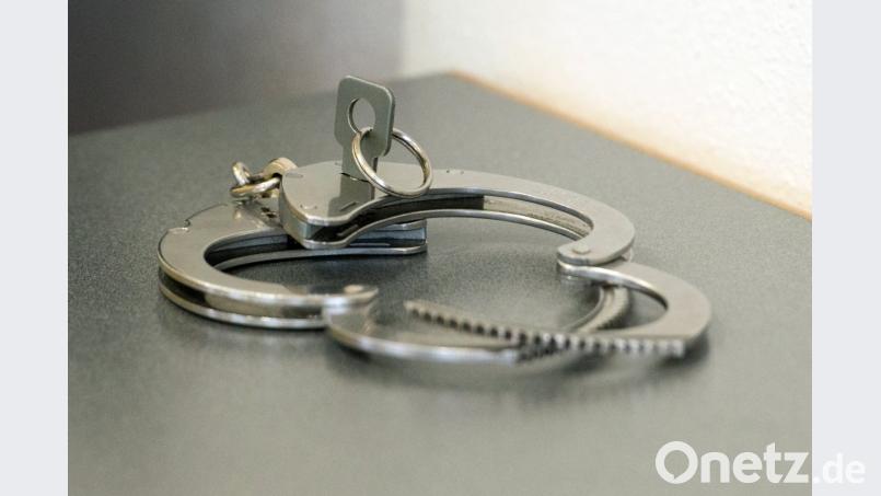 Handschellen liegen auf einem Tisch. Foto: Armin Weigel/Archiv Bild: Armin Weigel