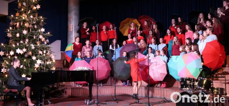 Kein Schnee, dafür "Regentropfen", die der Unter-, Mittel- und Oberstufenchor erfolgreich mit bunten Schirmen abwehrt. Bild: Kunz