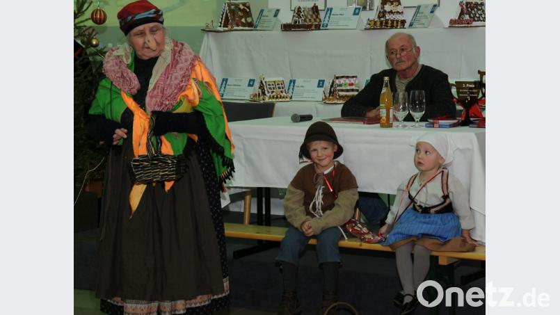 Die kleine Gretel schaut ein bisschen verzagt, ihr Bruder Hänsel grinst aber schon ganz kess: Schließlich ist die Hexe, die bei der Klösterlichen Weihnacht vorbeikommt, gar nicht so bös. Reinhold Escherl (im Hintergrund) erzählt die ganze Geschichte. Bild: gfr