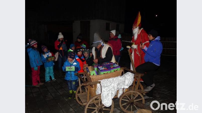 Zum wiederholten Mal kommen die Kinder des Sportvereins Trevesen auf den weihnachtlich geschmückten Hof der Familie Lorenz. Nikolaus und Knecht Ruprecht verteilen an sie Süßigkeiten. Bild: twg