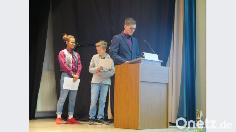 Die drei Schülersprecher Joshua Riedl, Henry Wegmann und Isabelle Frazier (von rechts) lesen die Laudatio zur Ehrung der außerunterrichtlichen Aktivitäten ihrer Schule vor. Bild: jzk
