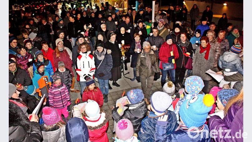 Die Menschen versammeln sich auf dem Pfarrplatz, pflegen die Geselligkeit und lassen sich von den Weihnachtsliedern der Kinder vom Kindergarten unterhalten. Bild: zer