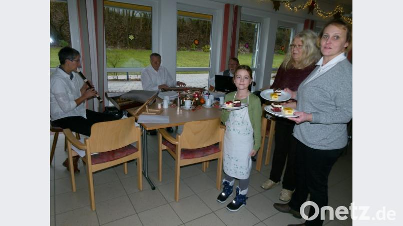 Auch Ida, Enkeltochter von Heimleiterin Manuela Schusser, will beim Servieren dabei sein: Während die Stubnmusi weihnachtliche Lieder spielt, lassen sich die Bewohner des BRK-Seniorenheimes Kuchen schmecken. Bild: rn