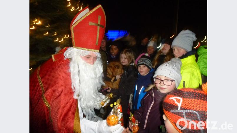 Der Nikolaus füllte die aufgehaltenen Hände der Kinder. Bild: bk