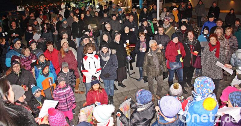 Die Menschen versammeln sich auf dem Pfarrplatz, pflegen die Geselligkeit und lassen sich von den Weihnachtsliedern der Kinder vom Kindergarten unterhalten. Bild: zer