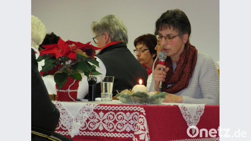 An einem mit einem Weihnachtsstern und einer Kerze geschmückten Tisch liest Gertraud Mois die "Oberpfälzer Weihnacht". Bild: adj