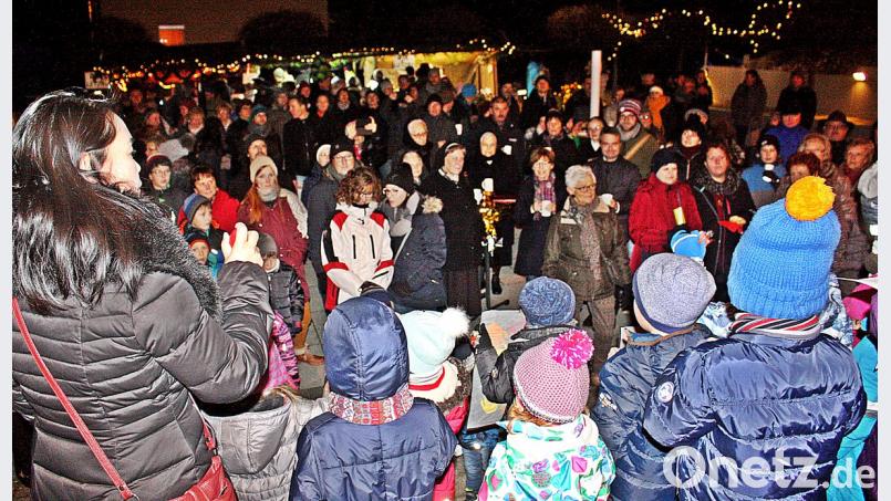 Die Menschen versammeln sich auf dem Pfarrplatz, pflegen die Geselligkeit und lassen sich von den Weihnachtsliedern der Kinder vom Kindergarten unterhalten. Bild: zer