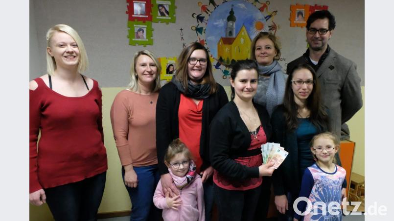 Mitglieder der katholischen Kindertagesstätte St. Johannes M. Vianney mit Vorsitzenden Evelyn Weidner (vorne, rechts ) überreichen an Ralf und Tina Kiener (hinten, von rechts ) den Spendenbetrag. Bild: le