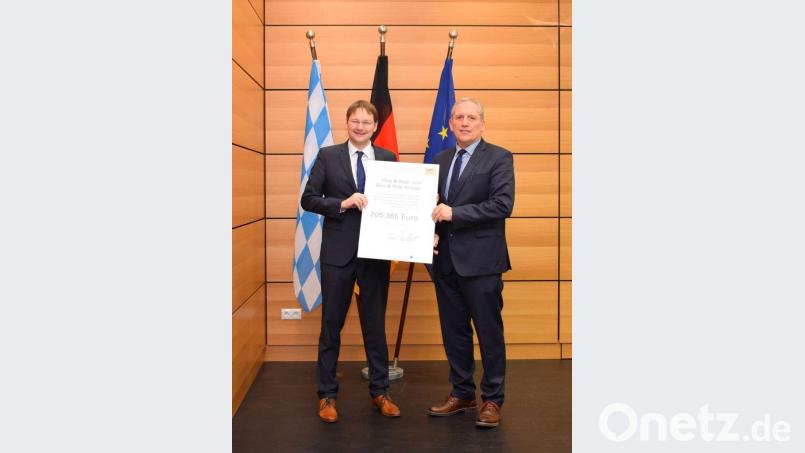 Aus den Händen von Bayerns Verkehrsminister Hans Reichart (links) nimmt Bürgermeister Werner Prucker den Förderbescheid für die Erstellung der Park-and-ride-Anlage in Empfang. Bild: exb