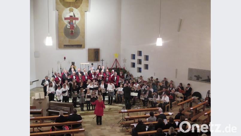 Beim gemeinsamen Schlusslied leitet Lucia Stelzer die Chöre und Nobert Lodes die Speichersdorfer Musikanten. Bild: jzk