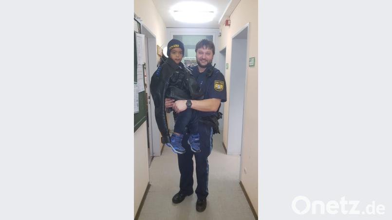 Noch ist die Jacke ein bisschen zu groß: Der Zweijährige durfte in der Polizeidienststelle in Selb eine Polizeijacke und -mütze tragen. Bild: Polizei Marktredwitz