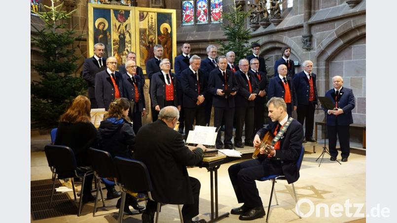 Der Männerchor des Gesang- und Orchestervereins Schönsee vor dem Altar der Frauenkirche in Nürnberg, links die Instrumentalisten mit Zither, Hackbrett, und Gitarre. Bild: mmj